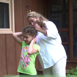 woman checking for ticks in girl's hair